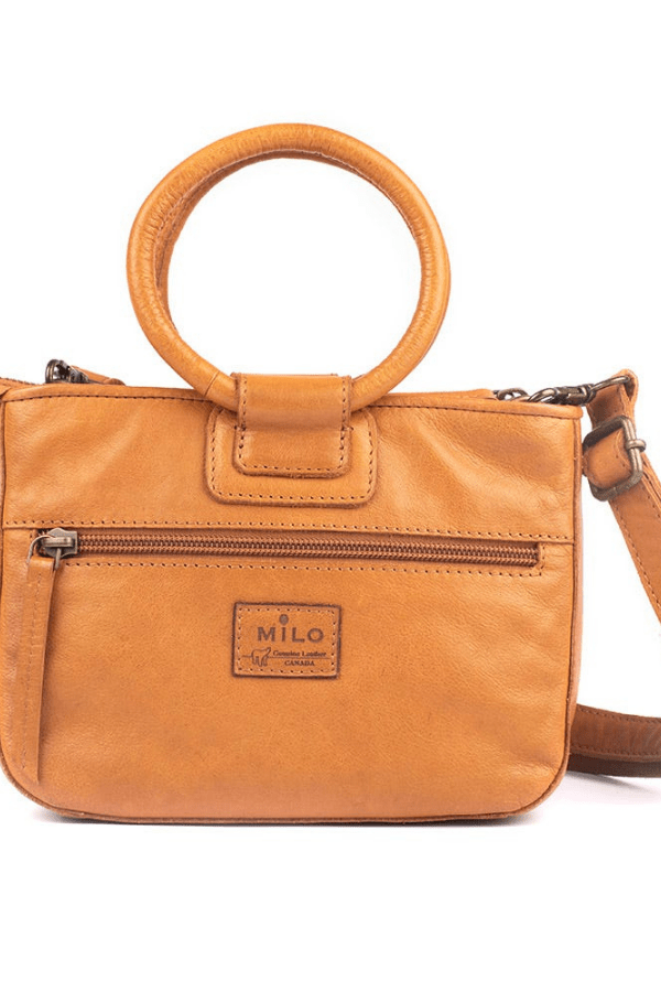 Brown leather handbag with circular handle on a white background