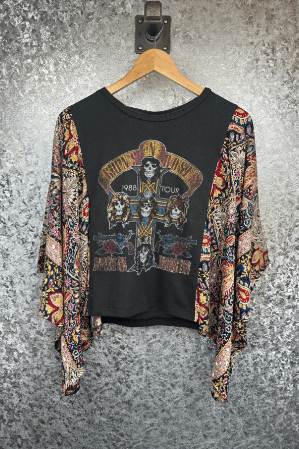 Black graphic sweatshirt with colorful patterns on a hanger against a textured gray background