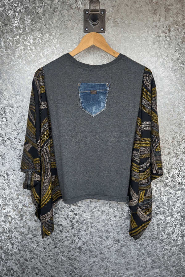 Gray sweater with a denim pocket design on a textured gray background