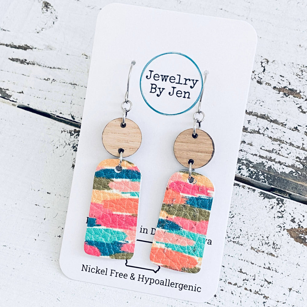 Colorful earrings displayed on a white card with logo.