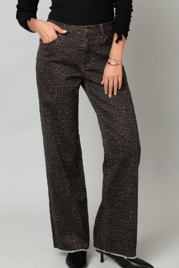 Woman wearing cheetah print denim pants against a white backdrop.