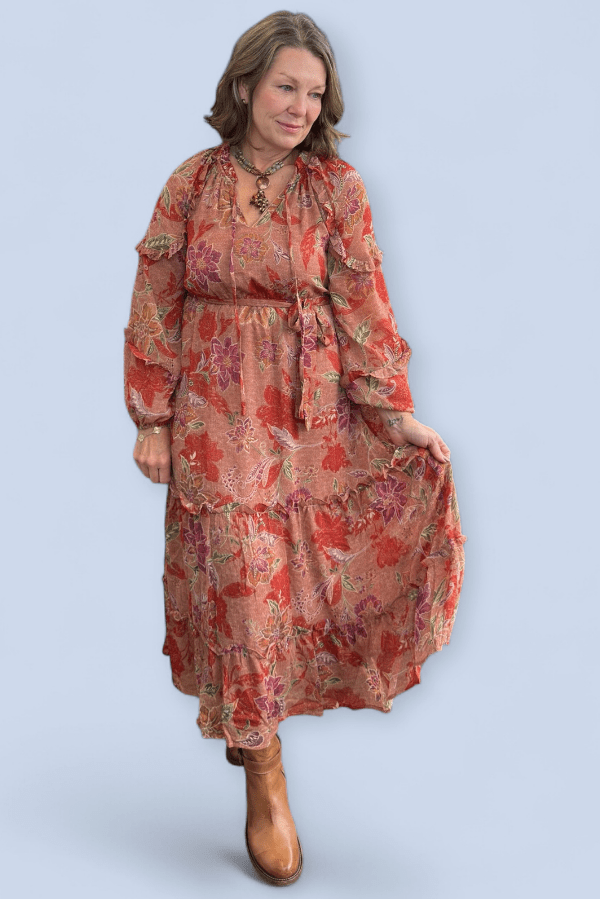 Woman wearing a floral dress with long sleeves on a light blue background