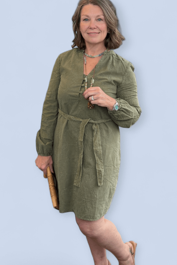 Woman wearing a green dress against a light blue background