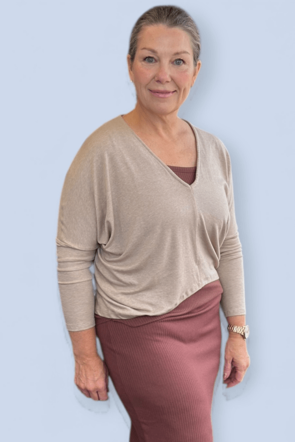 Woman wearing a neutral color v neck top.
