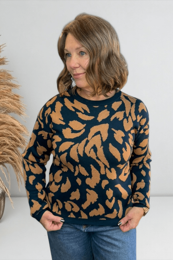 Woman wearing a leaf print fall sweater.