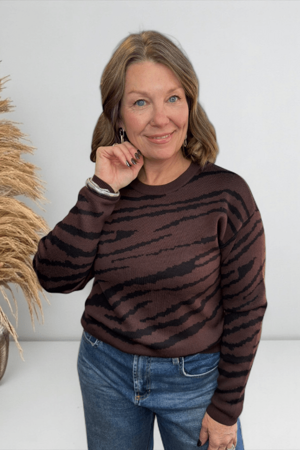Woman wearing brown zebra print sweater.