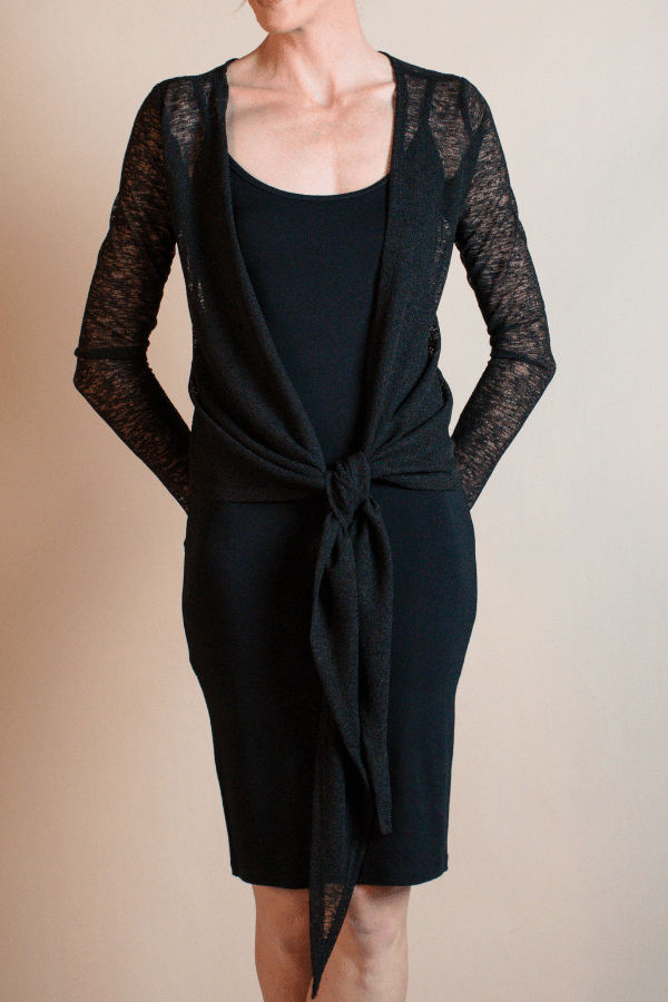 Black dress with lace sleeves on a neutral background