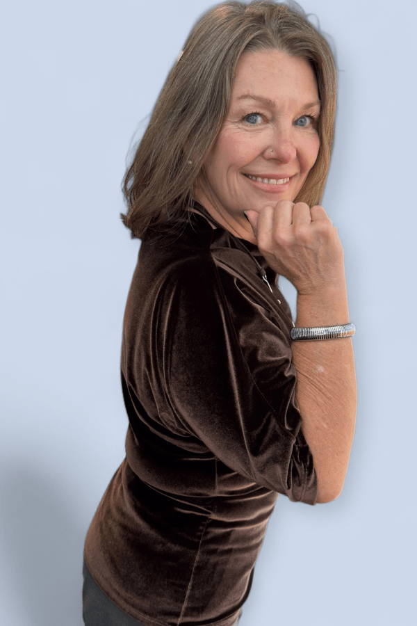 Woman wearing a brown velvet dress against a light blue background