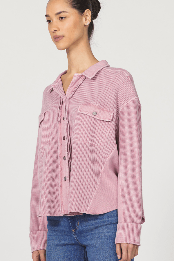 Woman wearing a pink checkered shirt and blue jeans on a white background