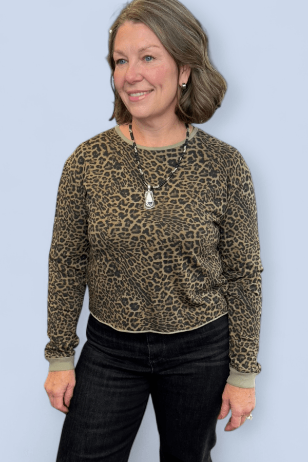 Woman wearing a leopard print sweater against a light blue background