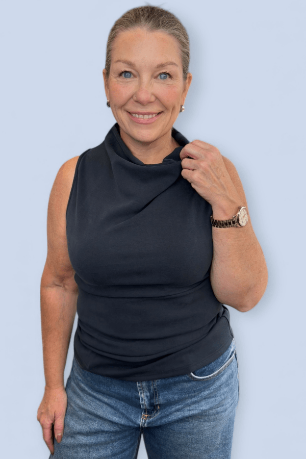 Close up of a woman wearing a black sleeveless top.