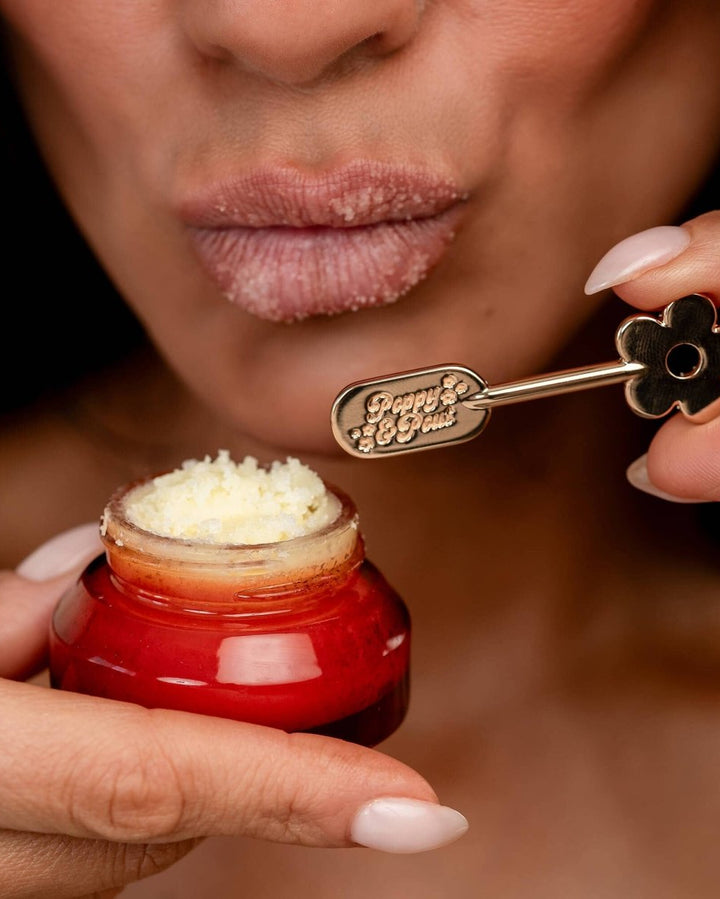 Gold Daisy Lip Care Spatula being used in orange jar.