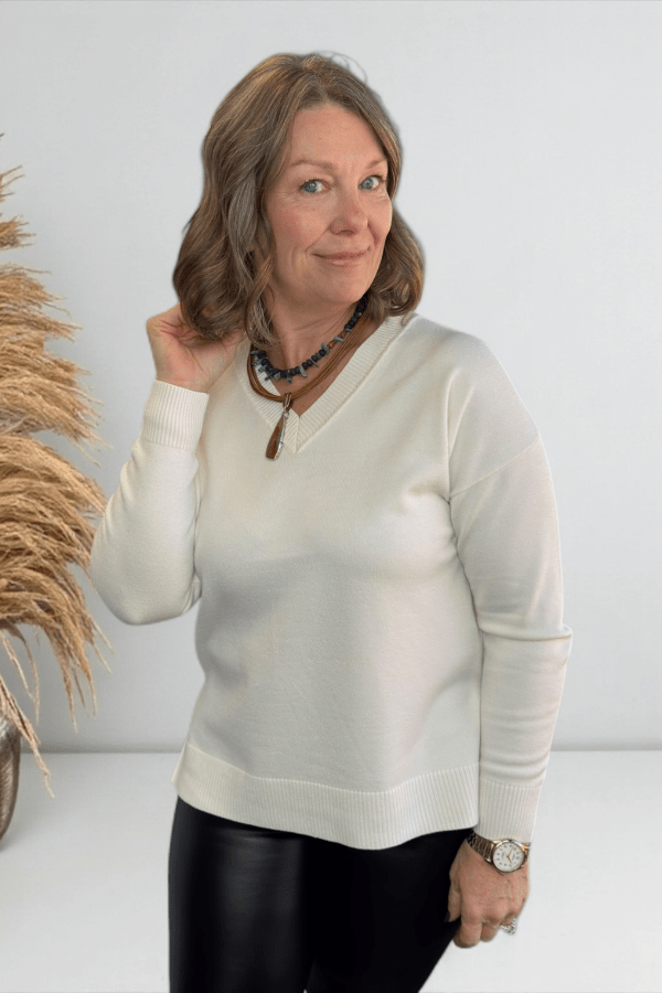 Woman wearing a white sweater with a neutral background