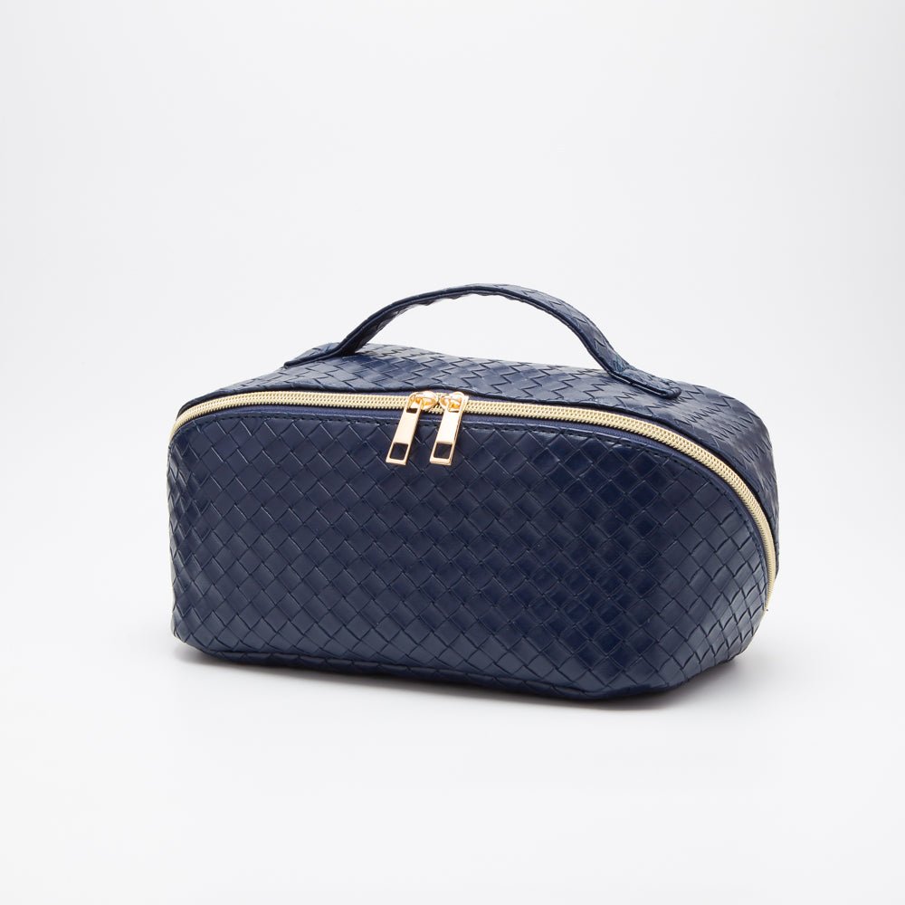 Navy blue woven travel bag with gold zipper on a white background