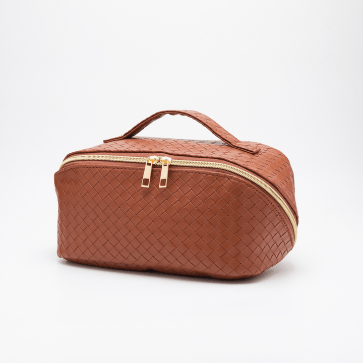 Brown makeup up bag with a handle and gold zipper on a white background.