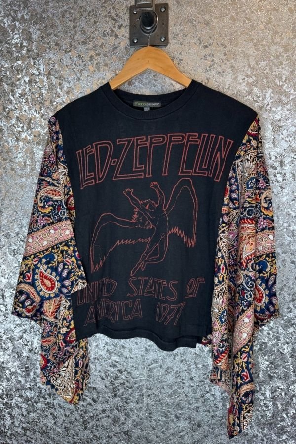 Black LED Zeppelin sweatshirt with colorful sleeves on a hanger against a textured wall.
