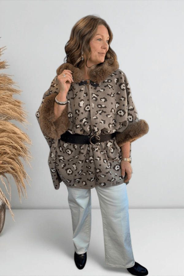 Model wearing a leopard faux fur hoodie cape belted with open front and clasp closure.