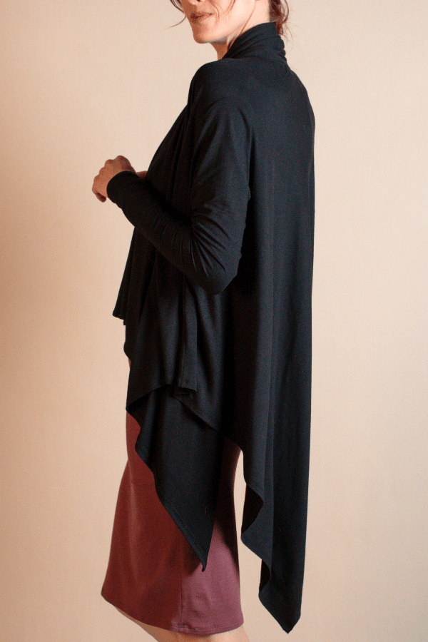 Person wearing a black and maroon dress against a beige background