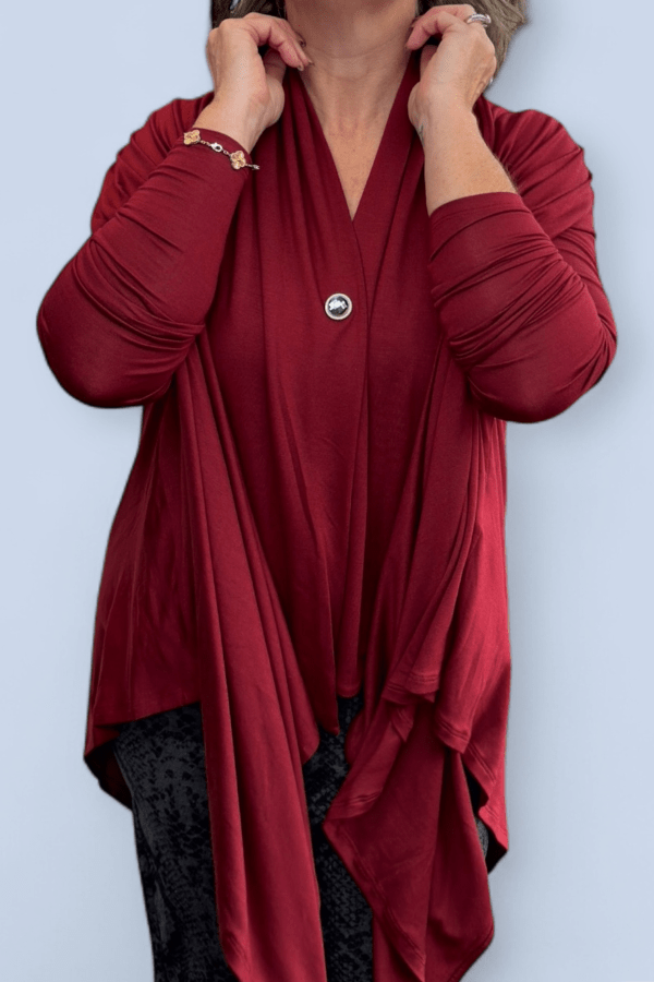 Red long-sleeve top with a button detail on a light blue background