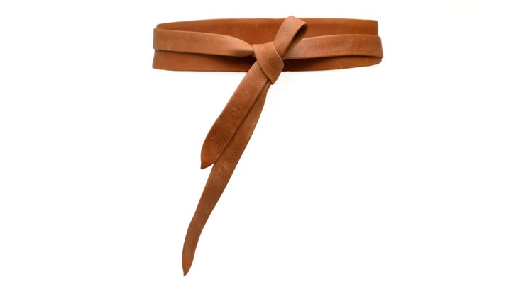 Brown suede belt with a bow on a white background