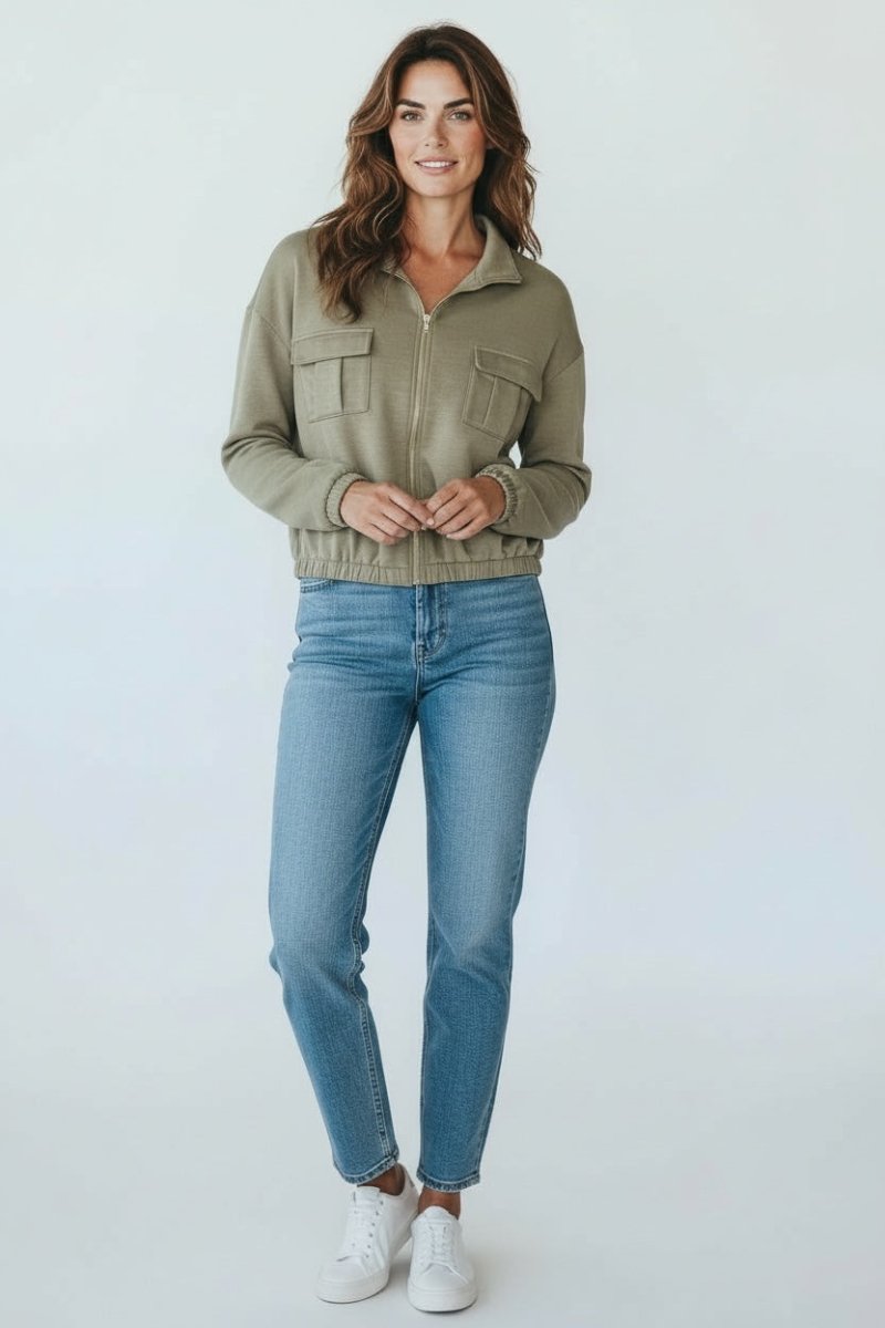 Woman wearing a green jacket and blue jeans on a white background