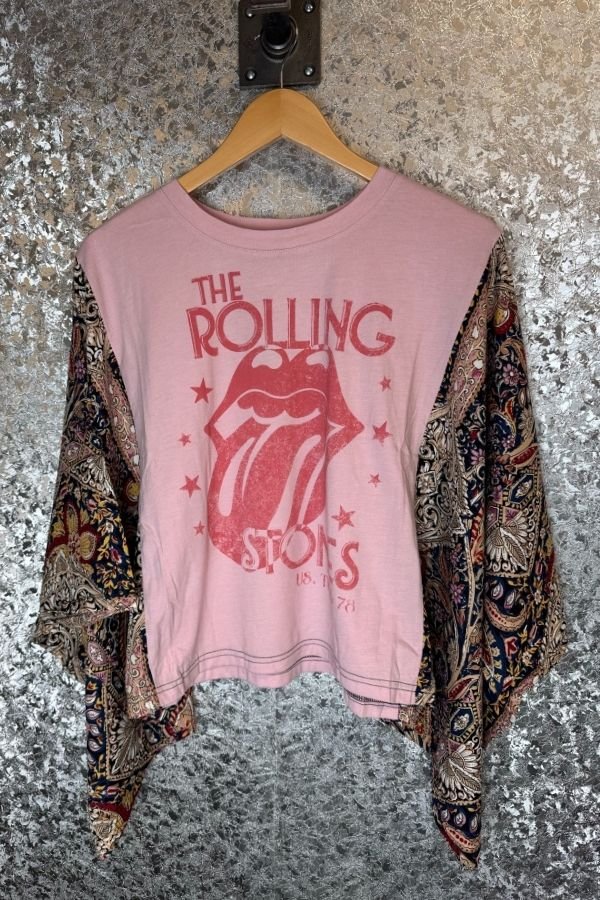 Pink 'The Rolling Stones' t-shirt on a hanger with a patterned scarf.