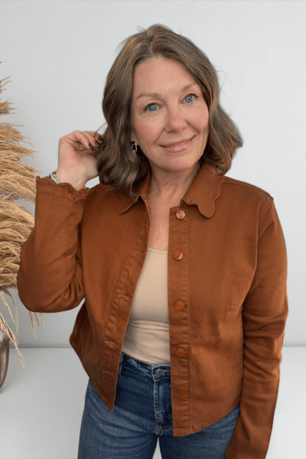 Woman wearing a brown jacket with a white background
