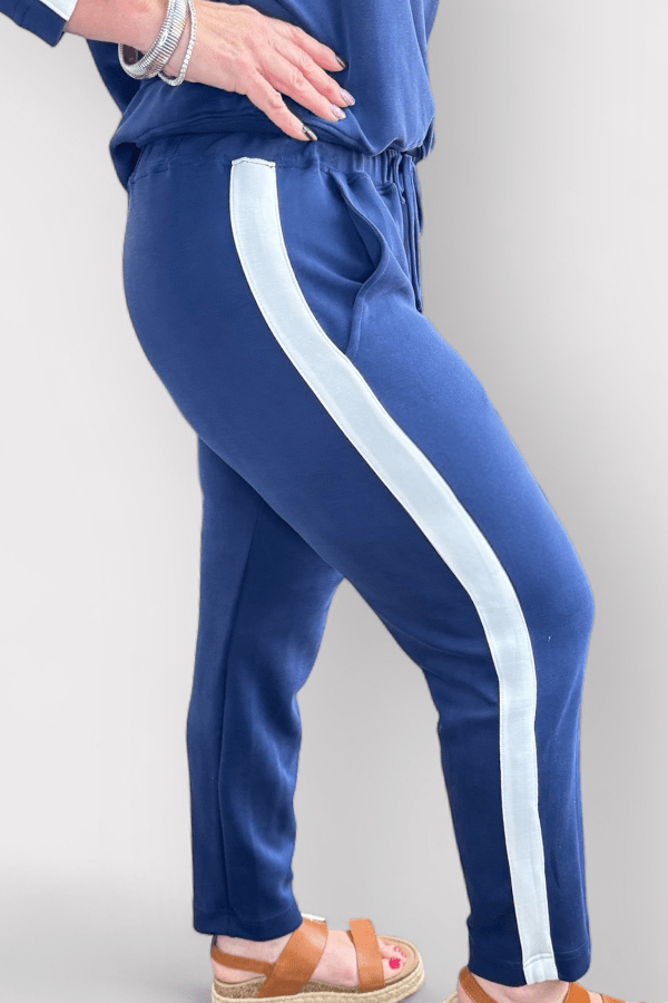 Blue tracksuit with white side stripe on a plain background