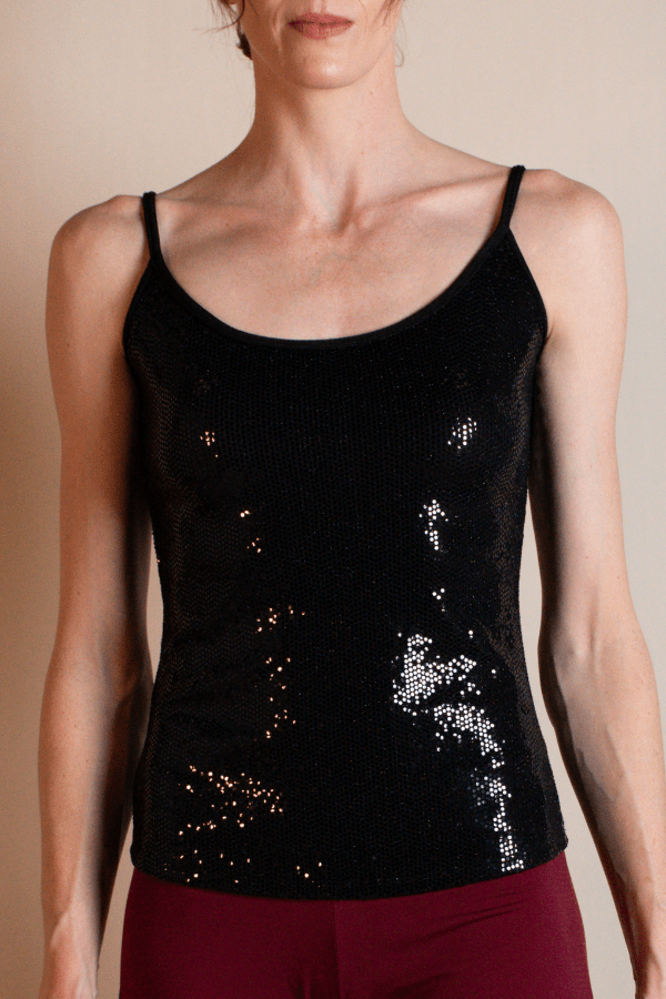 Black sequin tank top worn by a person on a beige background