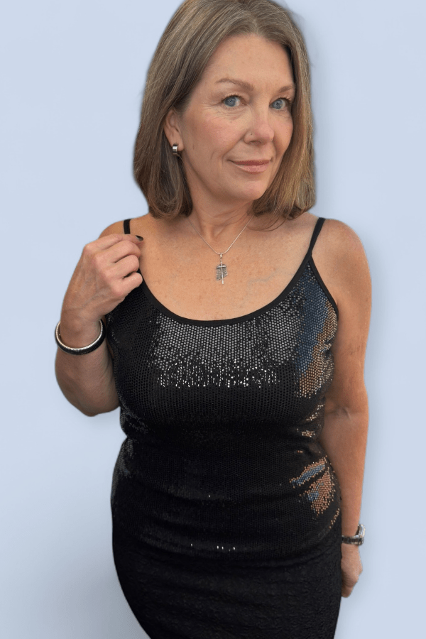 Woman wearing a black sequined dress against a light blue background