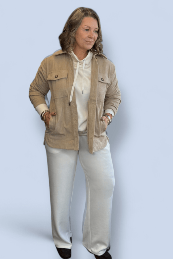 Woman wearing an ivory two piece with a tan shacket over.