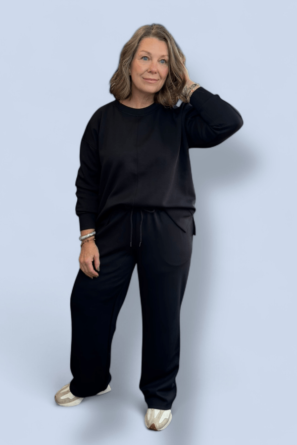 Woman wearing a black outfit against a light blue background