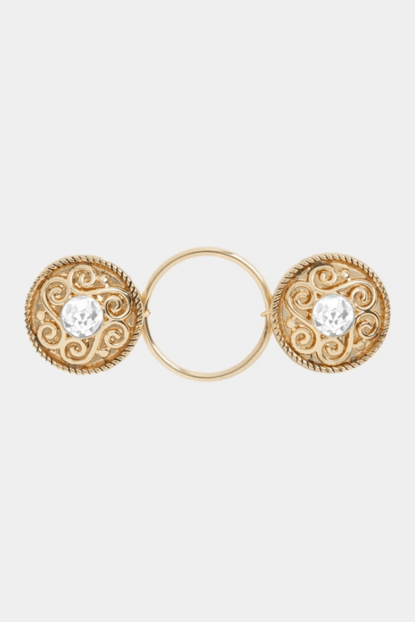 Gold fastener with intricate designs and clear gemstones on a white background