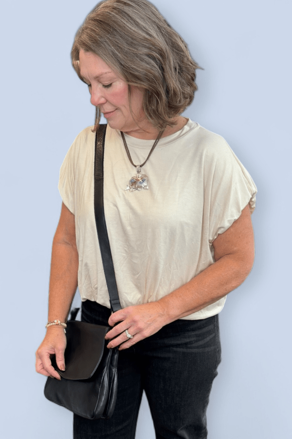 Woman holding a black bag against a light blue background