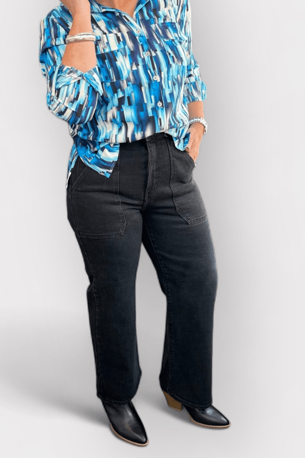 Woman wearing blue button up and black pants.