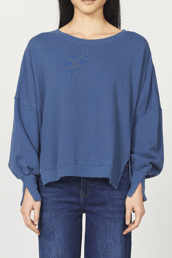 Blue sweater worn by a person on a white background