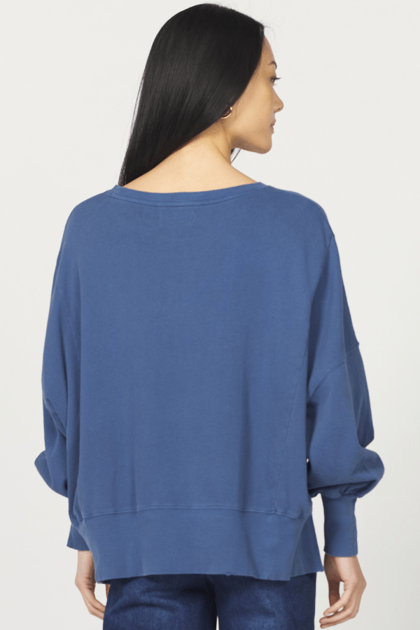 Woman wearing a blue sweater against a white background
