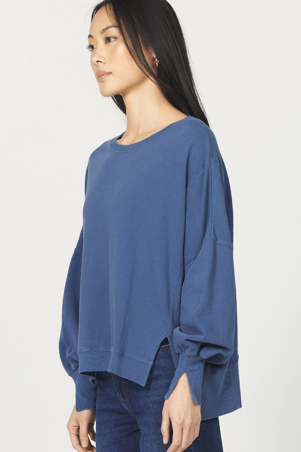 Woman wearing a blue sweater against a white background