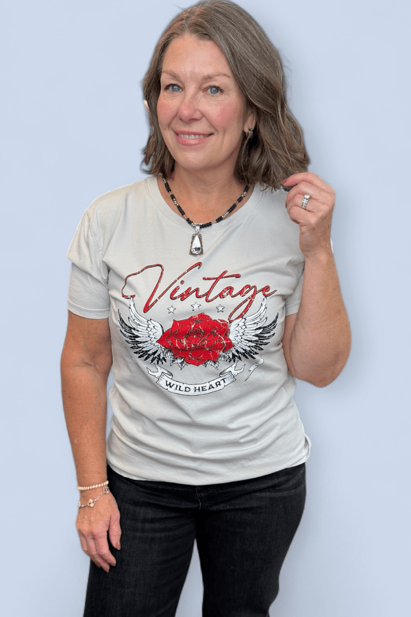 Woman wearing a white t-shirt with a red rose design and text on a light blue background