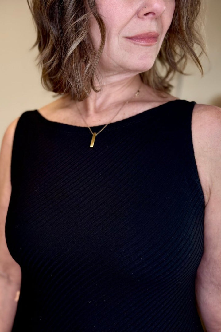 Woman showing the ribbed detail in the top of the dress.