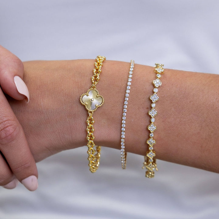 Annie Dainty Tennis Bracelet in Gold — front wrist view layered with clover designs