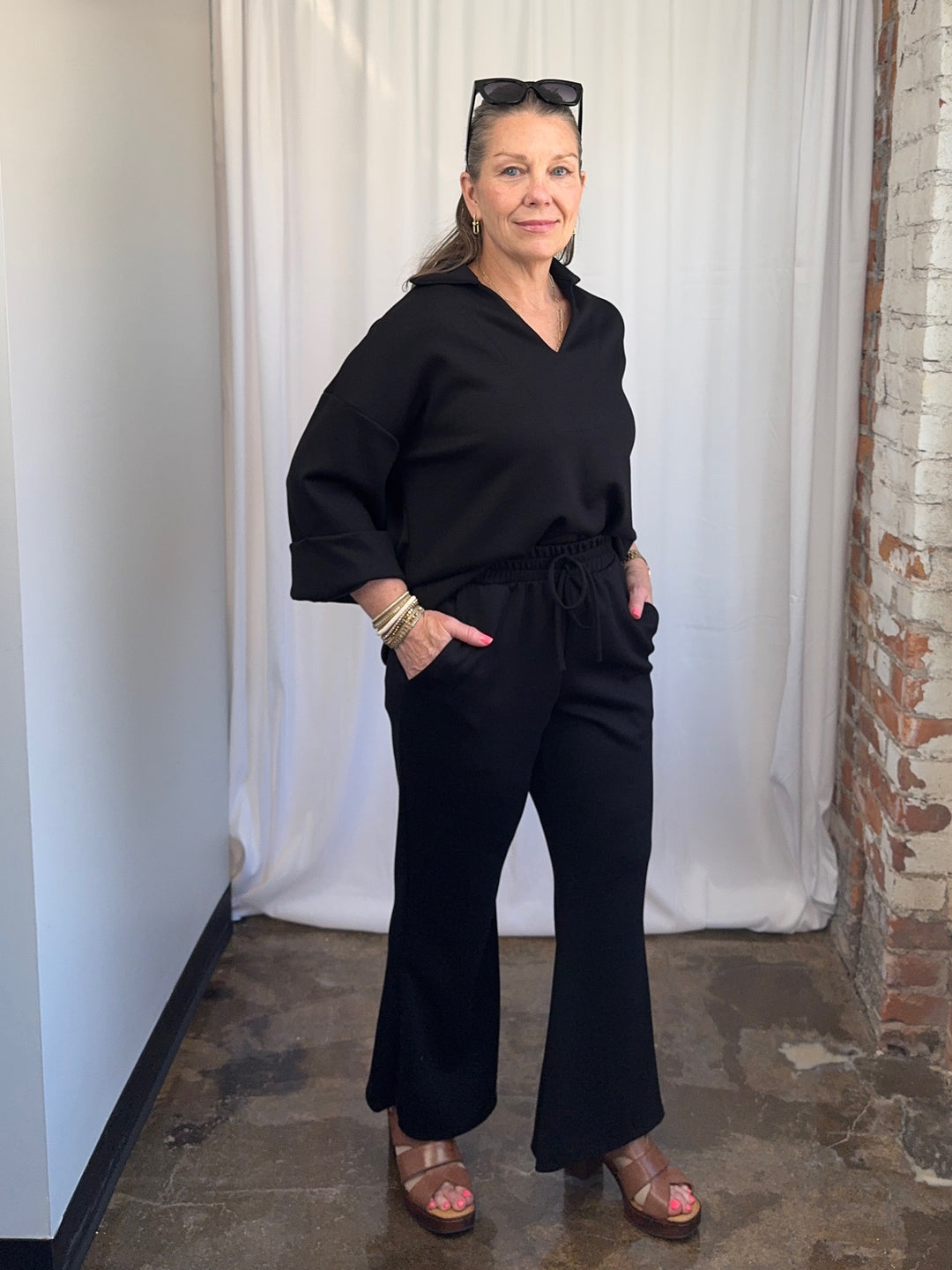 Close-up of Scuba Modal Split-Collar Wide-Leg Set in Black, structured open V-neck collar and cuffed sleeve detail on model