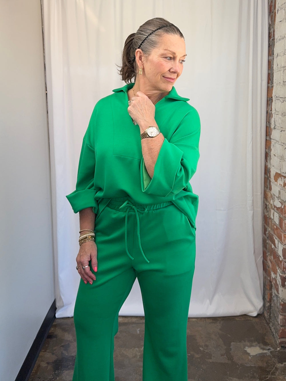 Carole Christian Scuba Modal Split-Collar Wide-Leg Set in Kelly Green, three-quarter angle view showing full two-piece set with dropped shoulder top on model