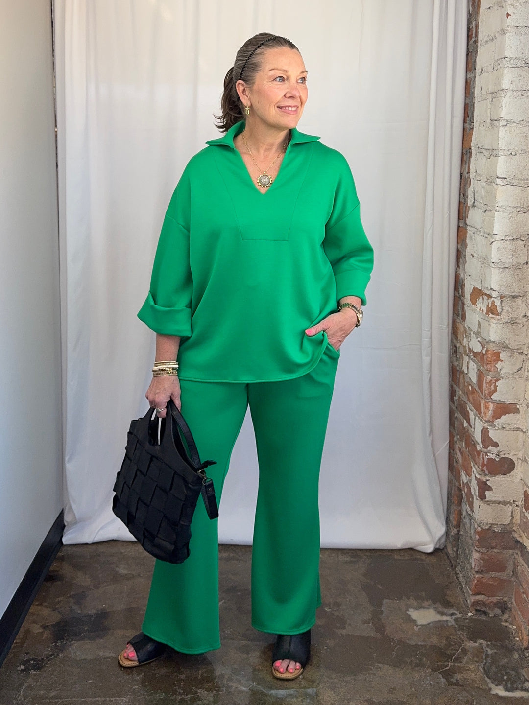 Carole Christian Scuba Modal Split-Collar Wide-Leg Set in Kelly Green, three-quarter view with hand in pocket showing split-collar top and wide-leg pant on model