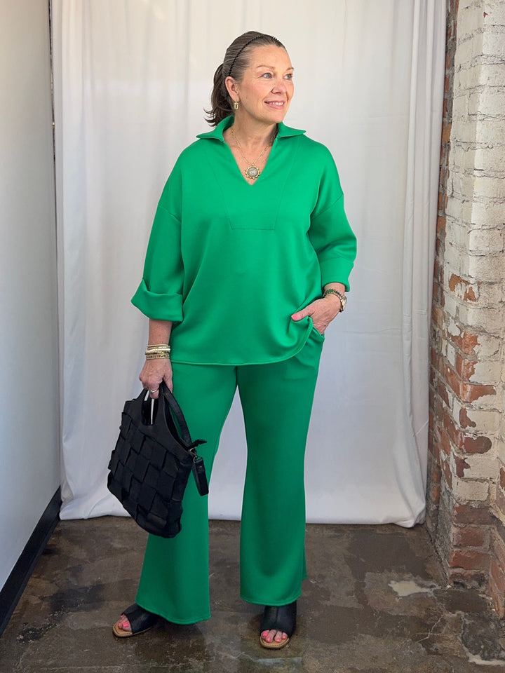 Carole Christian Scuba Modal Split-Collar Wide-Leg Set in Kelly Green, three-quarter view with hand in pocket showing split-collar top and wide-leg pant on model