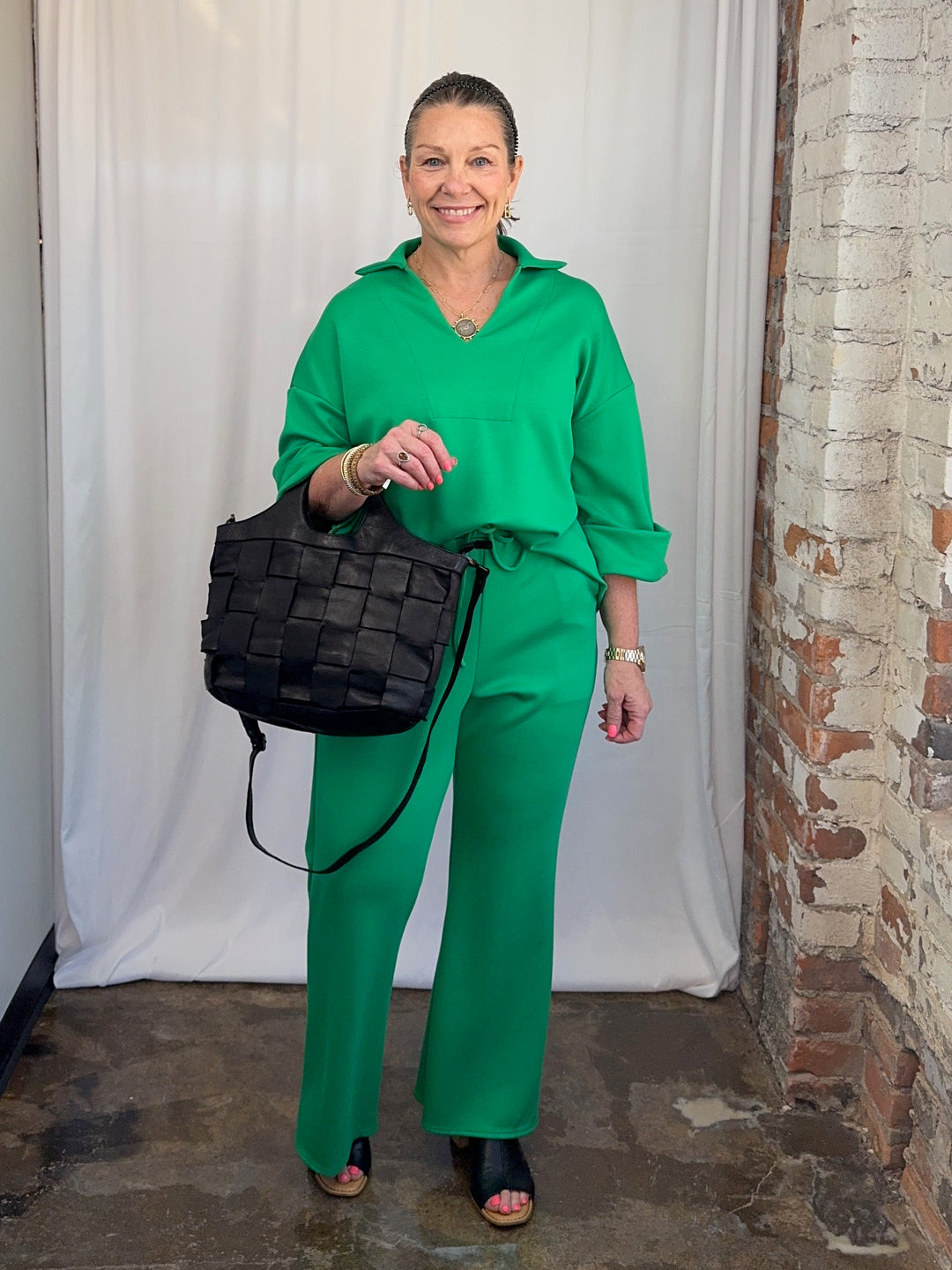 Carole Christian Scuba Modal Split-Collar Wide-Leg Set in Kelly Green, styled with black crossbody bag, full-length front view on model