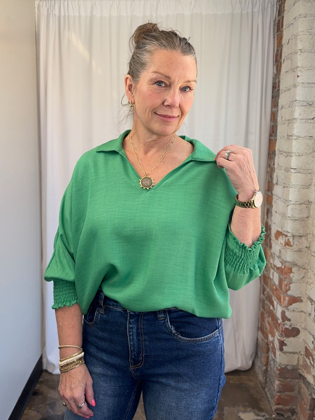 Carole Christian Relaxed Collar V-Neck Smocked Sleeve Blouse in Kelly Green, open collar and smocked cuff detail, close-up front view on model