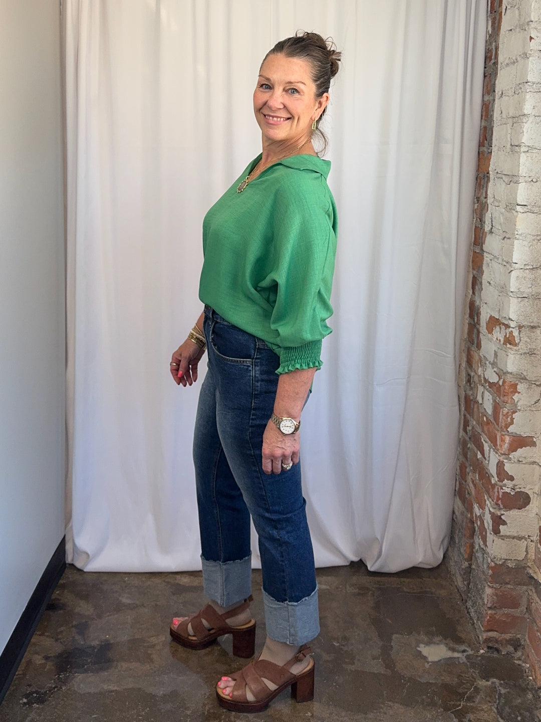 Carole Christian Relaxed Collar V-Neck Smocked Sleeve Blouse in Kelly Green, lightweight polyester with curved hem, side view on model