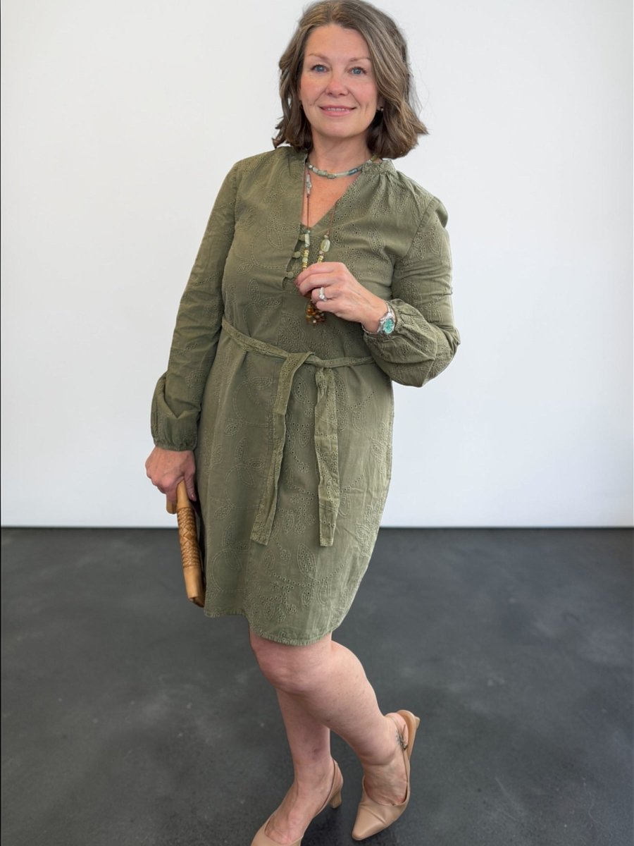 Woman wearing a green dress against a plain background