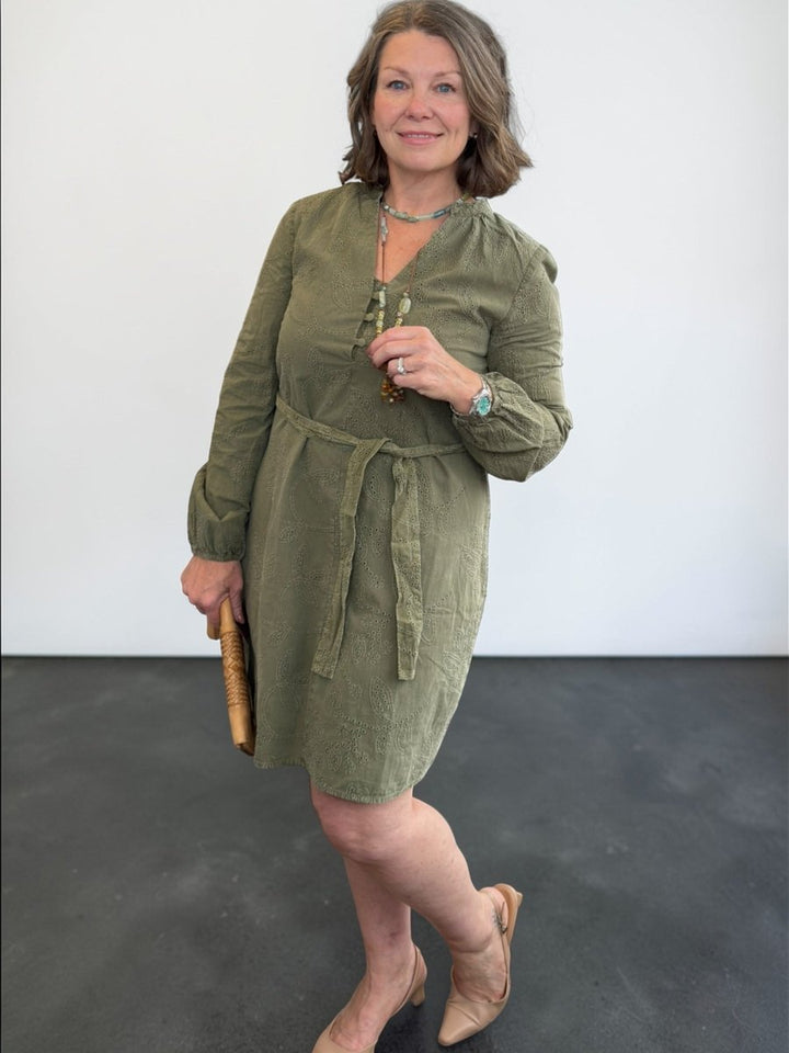 Woman wearing a green dress against a plain background
